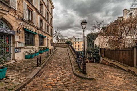 enge Gasse auf dem Montmartre in Paris mit Kopfsteinpflaster und Laterne